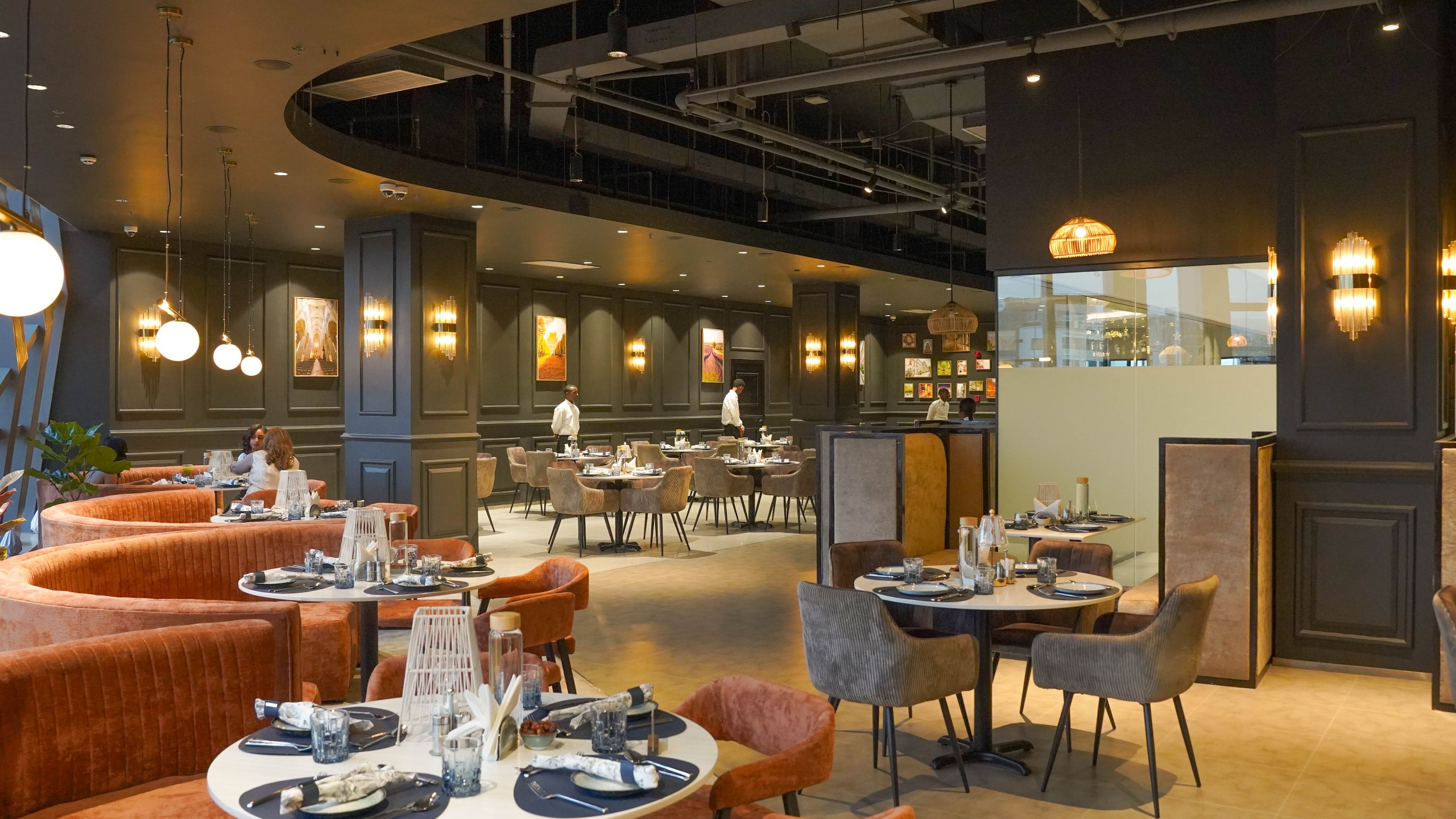 Rue Addis dining room — city-vintage booths, globe lights, and set tables above Addis Ababa